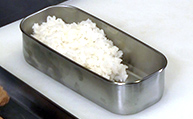 お弁当に白米を詰める。